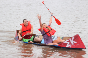 Shane Jones, undecided  sophomore, and Destiny Zynda, exercise physiology junior, are the first to finish at the MSU Cardboard Boat Race where students and organizations build a boat out of cardboard, and duck tape and race across Sikes Lake, Oct, 30. Photo by Francisco Martinez