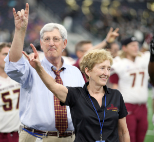 Charlie Carr, athlectic director, and Suzanne Shipley, Midwestern State University president, throw up the "stang sign" while the band performs the alma mater during the end of Eastern New Mexico University vs. MSU game at AT&T Stadium, Sept. 19. Photo by Francisco Martinez