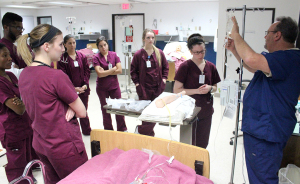 In their second semester, nursing students in the class, Basics, taught by Ronald Crone in the J.S. Bridwell Regional Simulation Center, learn how to put an IV in their patient and control the fluid amount that goes through the tube.