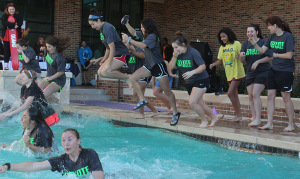 The Coyote Softball Team plunges on Jan. 30. Wichita Falls High School held a competition between teachers and whichever teacher had the most money put in their bucket had to jump. Coach Bingham "won" and the team decided to jump with their coach because they thought it would be a good bonding experience. Photo by Gabriella Solis
