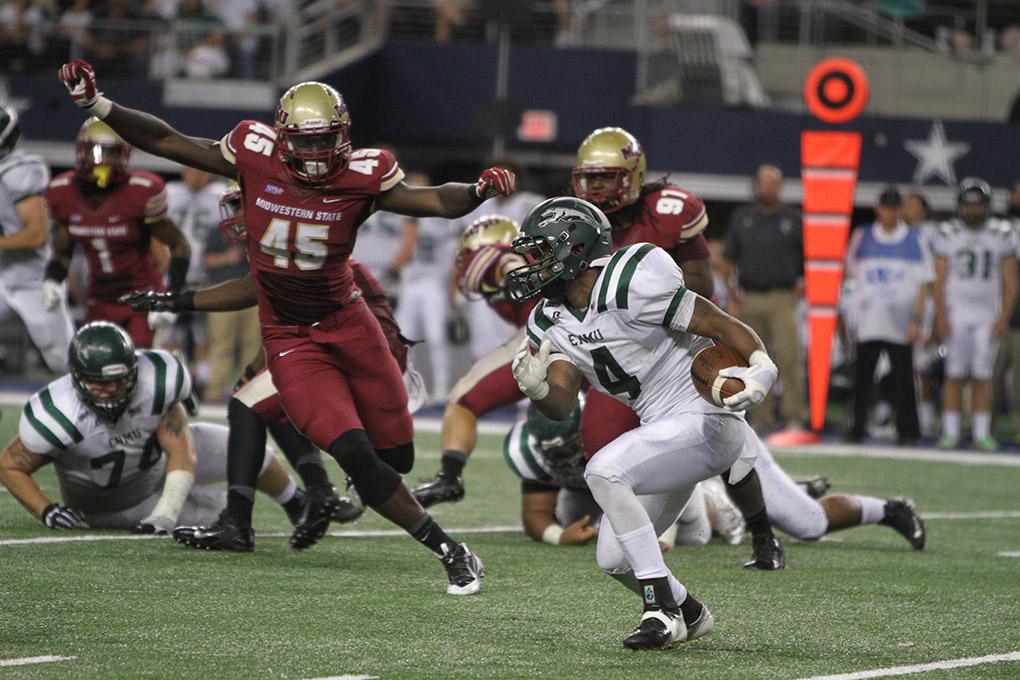 Eastern New Mexico running back D'Maujeric Tucker runs the ball as Midwestern State University's Phillip Sanders, kinesiology junior, tries to catch him at the Midwestern State University v. Eastern New Mexico game at AT&T Cowboys Stadium in Arlington, Sept. 20, 2014. Photo by Lauren Roberts