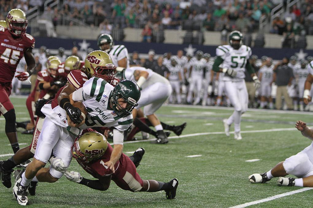 Eastern New Mexico quarterback Jeremy Buurma is tackled by Midwestern State University's Marqui Christian, criminal justice junior, and Deneldric Hudgens, sport and leisure studies senior, at Midwestern State University v. Eastern New Mexico game at AT&T Cowboys Stadium in Arlington, Sept. 20, 2014. Photo by Lauren Roberts