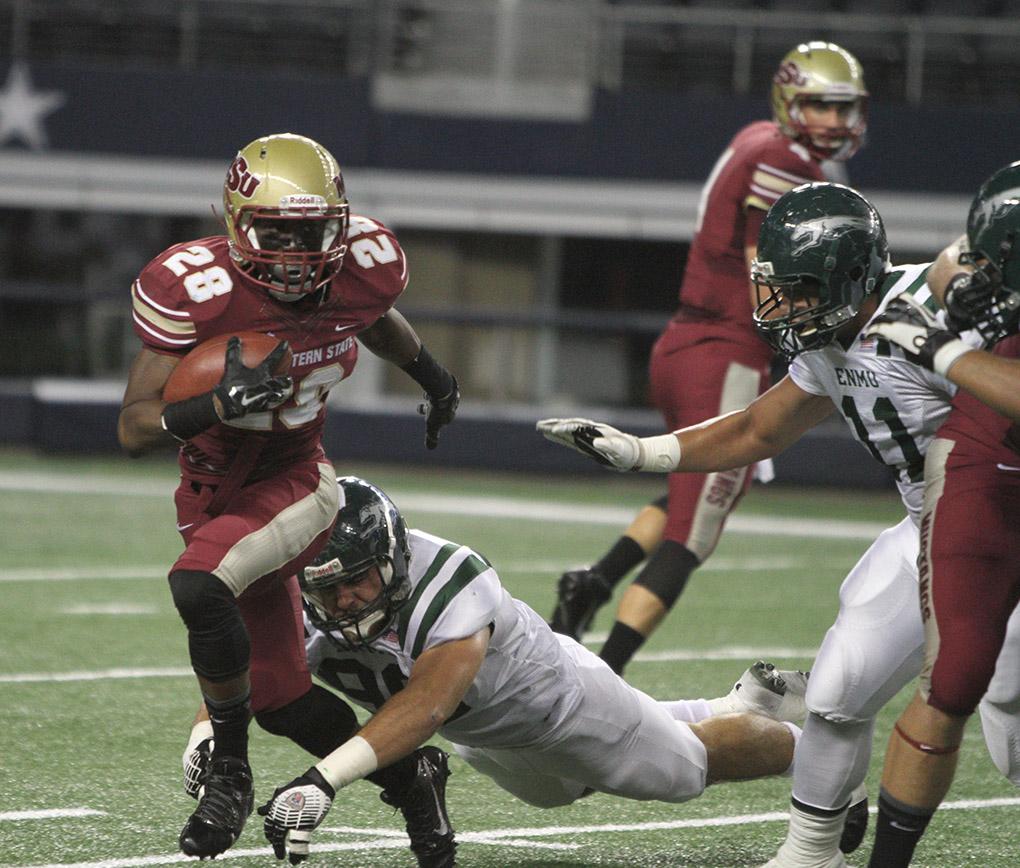 Dante Taylor, kinesiology sophomore, tries to make it around the line of scrimmage before being tackled at the  Midwestern State University v. Eastern New Mexico game at AT&T Cowboys Stadium in Arlington, Sept. 20, 2014. Photo by Lauren Roberts