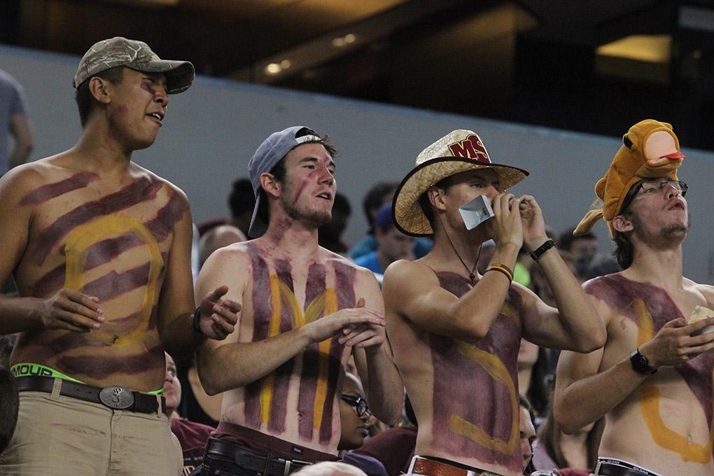 Kevin Nop, mechanical engineering freshman, Zach Davis, history and education freshman, Coleman Reidling, history sophomore, and Brandon Allen, mechanical engineering sophomore, cheers as members of the stang gang at Midwestern State University v. Eastern New Mexico game at AT&T Cowboys Stadium in Arlington, Sept. 20, 2014. Photo by Rachel Johnson