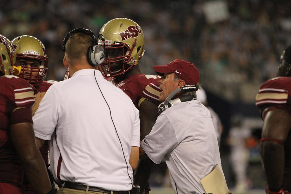 Head football coach Bill Maskill talks to players during a timeout at Midwestern State University v. Eastern New Mexico game at AT&T Cowboys Stadium in Arlington, Sept. 20, 2014. Photo by Lauren Roberts