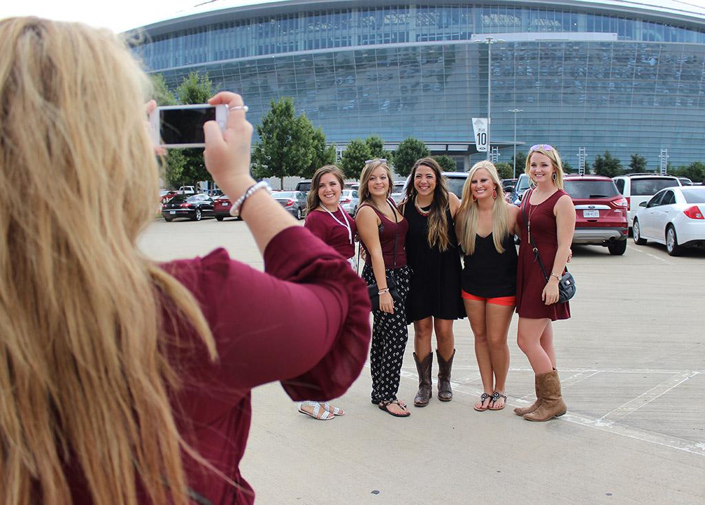 Avery Stout, radiology sophomore, Kylie Goble, nursing junior, Hannah Schulte, radiology sophomore, Ashlee Hasten, radiology senior, Kourtnie Renfro, dental hygene junior, get their picture taken by a friend outside of the AT&T Stadium while tailgating during the game. Photo by Rachel Johnson
