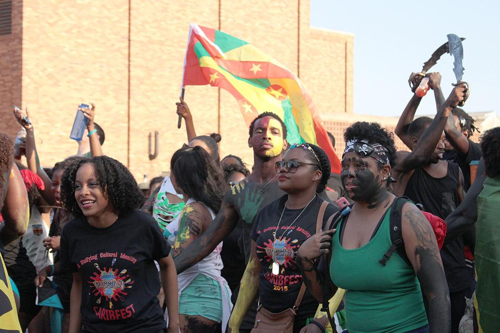 Participants in the 2015 CaribFest Parade celebrate by dancing, shouting, and waving flags  down Council Drive following a van with a D.J. and music, Sept. 25. Photo by Kayla White