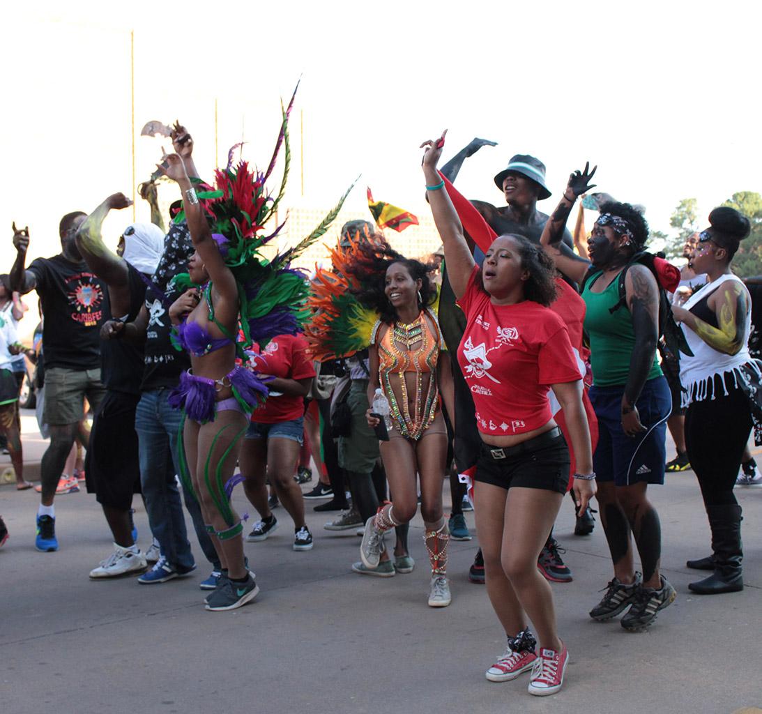 Participants in the 2015 CaribFest Parade celebrate by dancing, shouting, and waving flags  down Council Drive following a van with a D.J. and music, Sept. 25. Photo by Kayla White