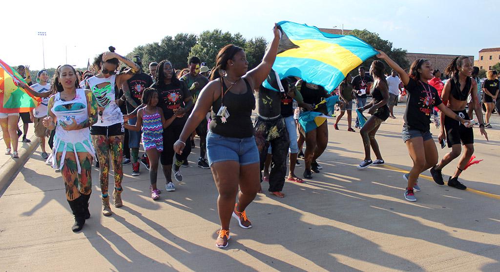 Students and participants in the CaribFest Parade 2015 start the parade in dance and song while waving the flags of different Caribbean islands, Sept. 25. Photo by Rachel Johnson