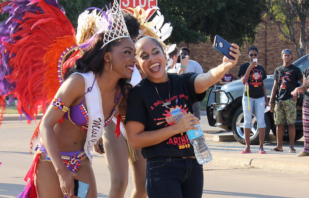 Amy Hanley, management information system sophomore, takes a picture with Jorrey Martin, special education sophmore and MIss CaribFest 2015, at the beginning of the CaribFest Parade 2015, Sept. 25. "I know the queen, we have been friends for a while," Hanley said. Photo by Rachel Johnson