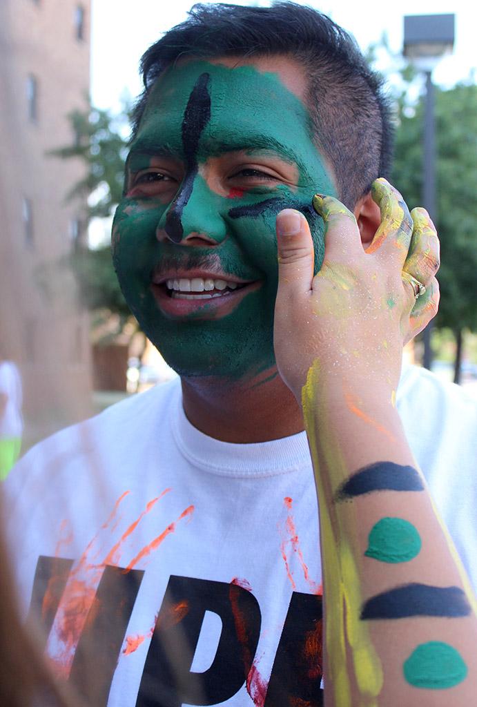 Francisco Ramos Armas, biology junior, gets his face and body painted in the Greenspace, that was provided by the University Programming Board, before the CaribFest Parade, that started between the parking lot behind  Prothro-Yeager and the parking lot by the practice fields, it ended at the Quad, Sept. 25. Photo by Rachel Johnson