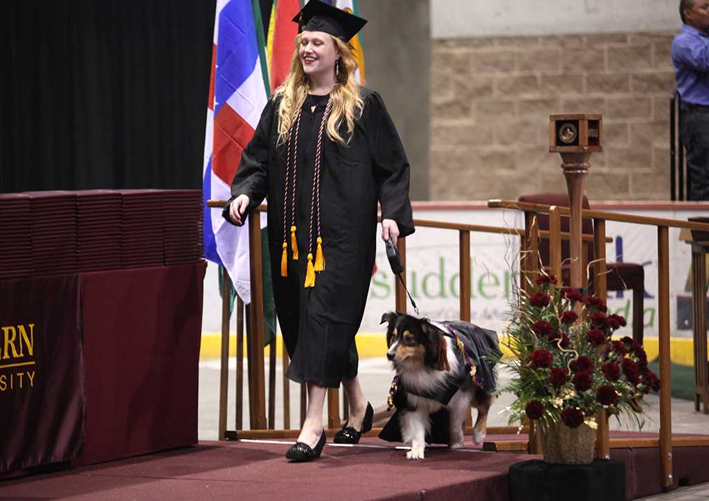 Shannon Smith, fine arts, walks along the stage with her dog in the Commencement Ceremony in Kay Yeager Coliseum Dec. 12, 2015
