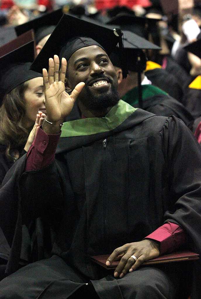 Rodney Holmes, excersize physiology, waves to his family members in the audience during the part in the ceremony where they have the graduates recognize their friends, family, professors, and people who helped them get to graduation day in Kay Yeager, Dec. 12. "I'm just feeling excitement, it's just crazy because O wamt tp say i'm the first on my dad's side of the family to finish this higher education," Holmes said.  Photo by Rachel Johsnon