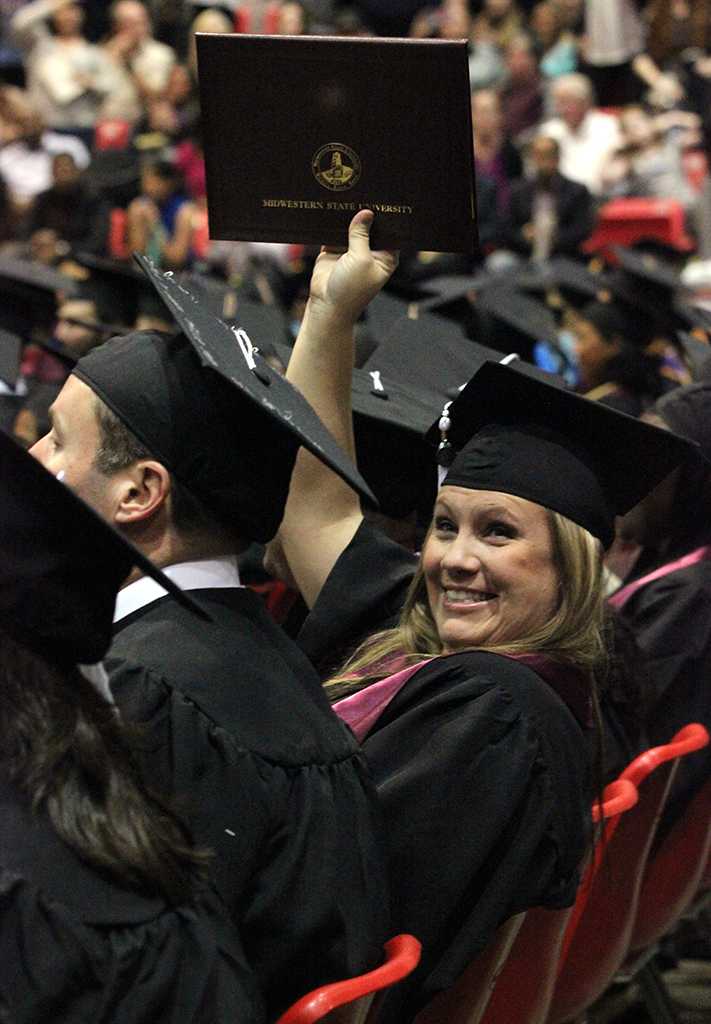 Liberty Billingsley, criminal justice, holds up her diploma case to the audience to show it off, in the Kay Yeager Colisem, Dec. 12. Photo by Rachel Johnson