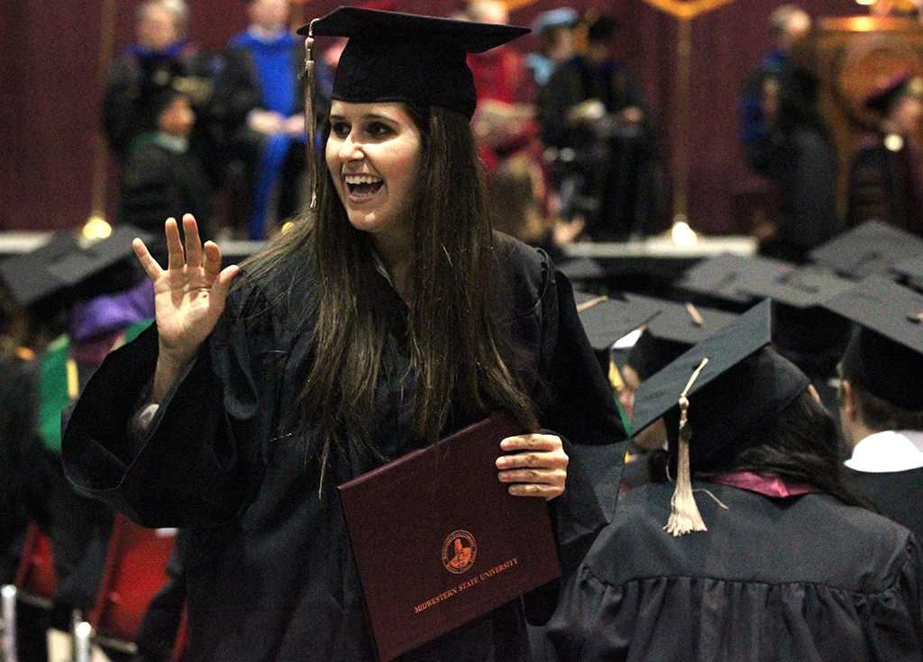 Devin Williams, marketing, waves at the professors after receiving her diploma case in the Kay Yeager Coliseum, Dec. 12. "[After getting my degree] I took a marketing postiion with Old Navy, and then just take it day by day and keep my options open," Williams said. Photo by Rachel Johnson