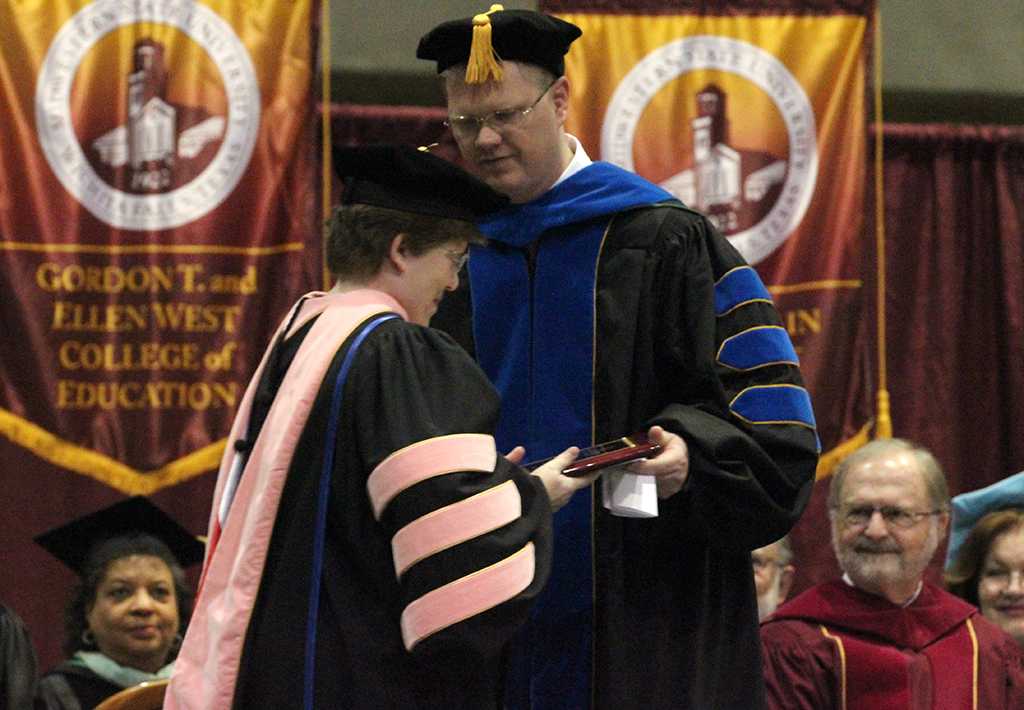 Susan Harvey, department chair and associate professor of music education, recieves the Faculty Award and was given the plaque by David Carlston, psychology professor, during the Commencement Cermony held in Kay Yeager Coliseum, Dec. 12. Photo by Rachel Johnson