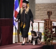 Shannon Smith, fine arts, walks along the stage with her dog in the Commencement Ceremony in Kay Yeager Coliseum Dec. 12, 2015