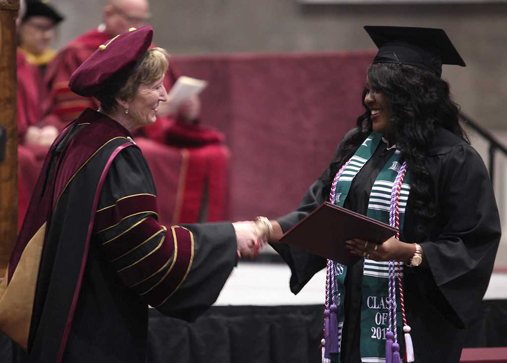 Suzanne Shipley, university president, congraduates Chimatara Nwabuko, nursing, as she walks across the stage at the Commencement  Ceremony in Kay Yeager Coliseum Dec. 12, 2015. Photo by Francisco Martinez