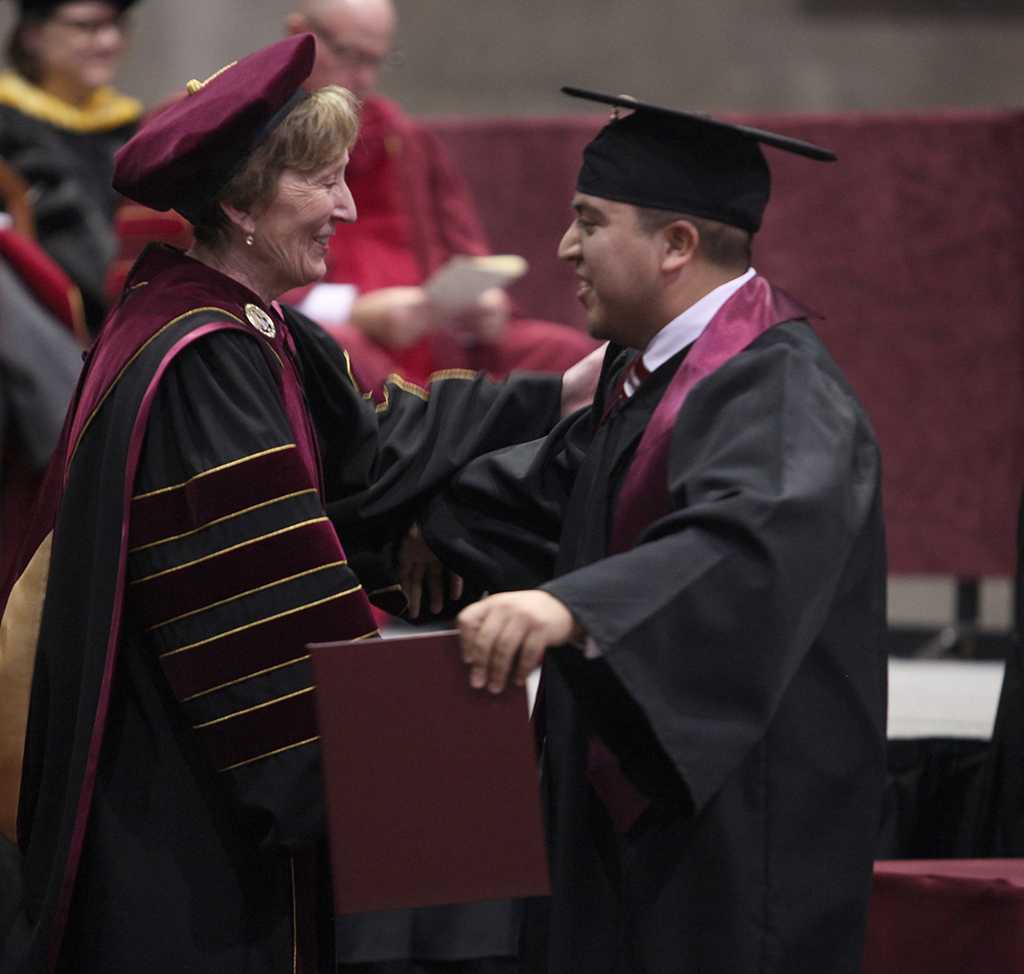 Chirstopher Portillo, business administration, hugs Suzanne Shipley, university president, as he walks across the stage at the Commencement Ceremony in Kay Yeager Dec. 12, 2015. Photo by Francisco Martinez