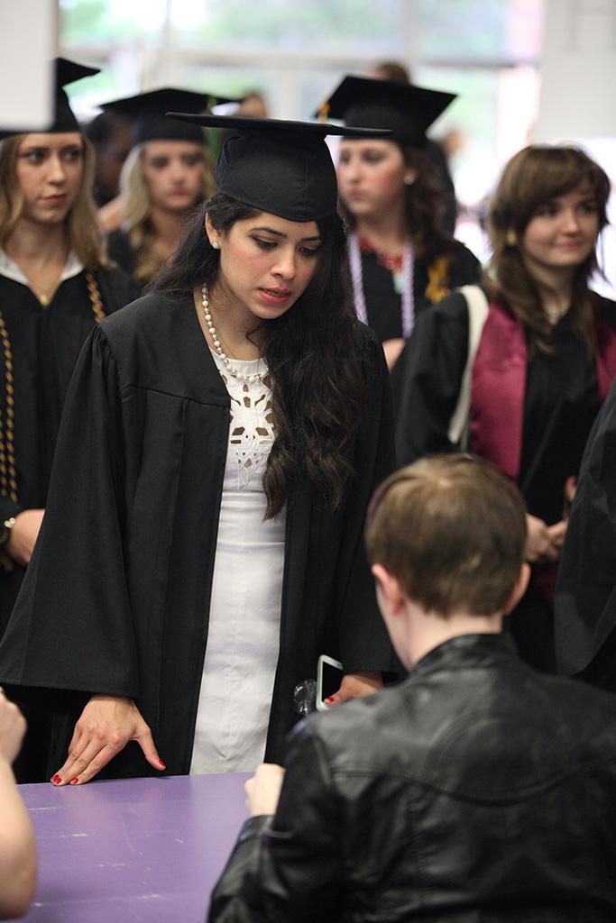 Andrea Giron, mechanical engineering, checks in and receives her name card at Midwestern State University graduation, May 16, 2015 at the Kay Yeager Coliseum. Photo by Francisco Martinez