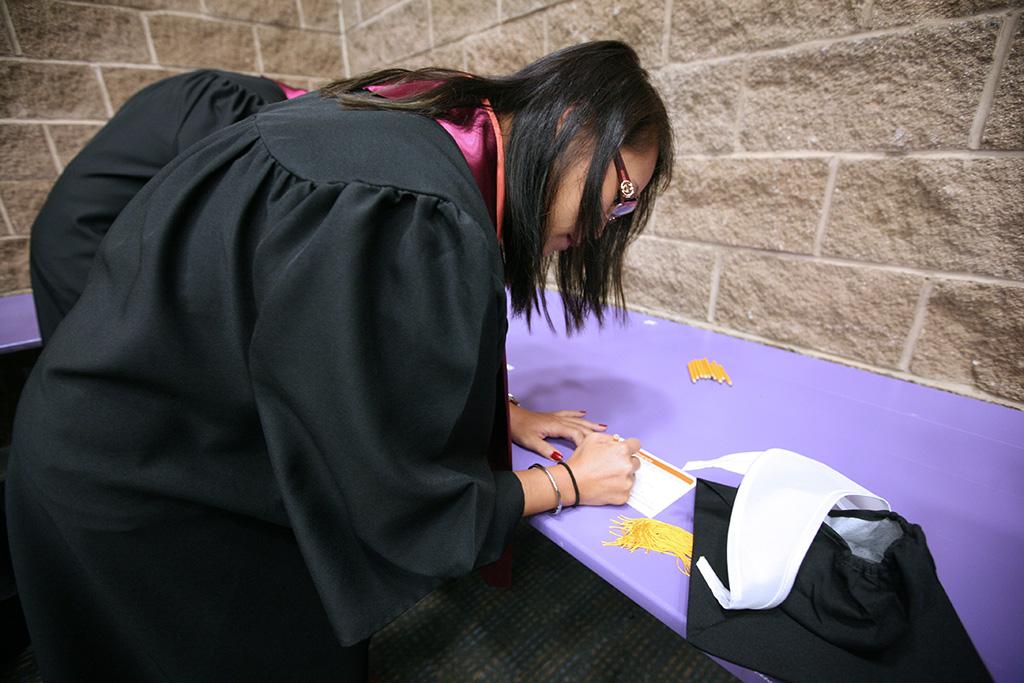 Christine Pae, biology clinical lab science, fills out his card with his name and information before the Midwestern State University graduation, May 16, 2015 at the Kay Yeager Coliseum. Photo by Rachel Johnson