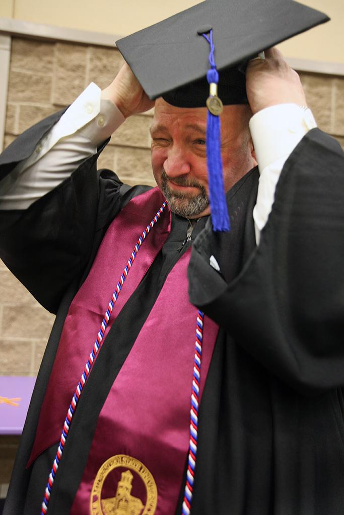 David Christiansen, respiratory care, fixes his cap before checking in to find his spot before the ceremony at the Midwestern State University graduation, May 16, 2015 at the Kay Yeager Coliseum. Photo by Rachel Johnson