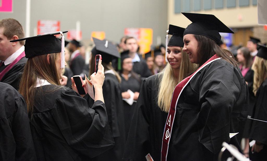 Michelle Sutton, English, takes a picture of Dusti Cribbs, English, and Taylor Baggett, English, at Midwestern State University graduation, May 16, 2015 at the Kay Yeager Coliseum. Photo by Francisco Martinez