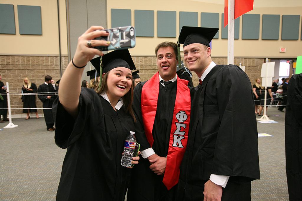 Cameron Hieb, athletic training, Robert Christian Magruder, athletic training, and Courtney Lyn Phillips, athletic training, take a group selfie at Midwestern State University graduation, May 16, 2015 at the Kay Yeager Coliseum. Photo by Rachel Johnson