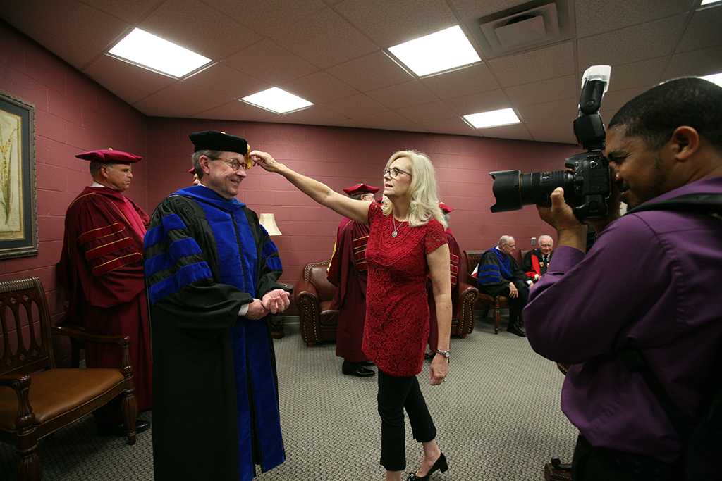 Cindy Ashlock, executive assistant to the President, moves Retiring University President Jesse Rogers' tassle out of his face int he greeen room before the ceremony at Midwestern State University graduation, May 16, 2015 at the Kay Yeager Coliseum. Photo by Rachel Johnson