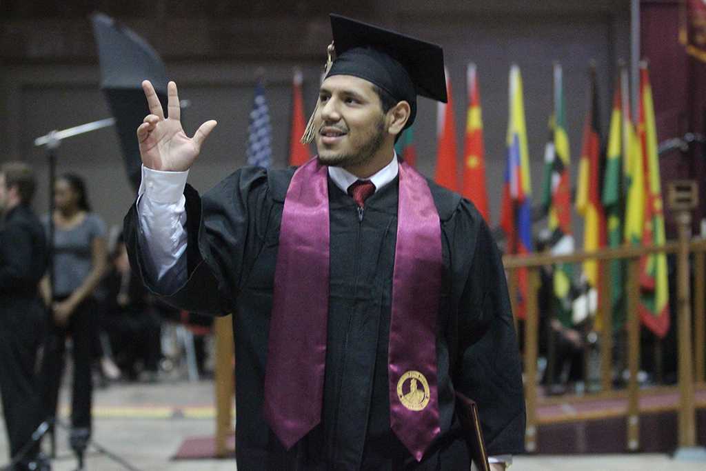 Edder Jaimes, business management, waves to the audience after walking the stage and receiving his diploma at Midwestern State University graduation, May 16, 2015 at the Kay Yeager Coliseum. Photo by Rachel Johnson