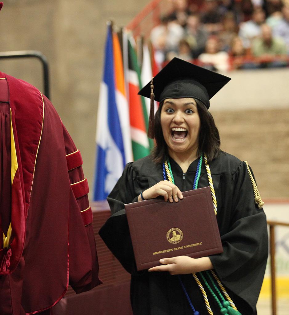 Ruby Arriaga, business senior, is full of joy after receiving her diploma at Midwestern State University graduation, May 16, 2015 at the Kay Yeager Coliseum. Photo by Francisco Martinez