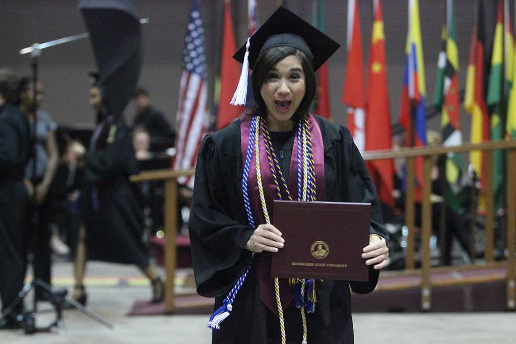 Sabina Marroquin, history, excitedly holds her diploma after walking the stage at Midwestern State University graduation, May 16, 2015 at the Kay Yeager Coliseum. Photo by Rachel Johnson