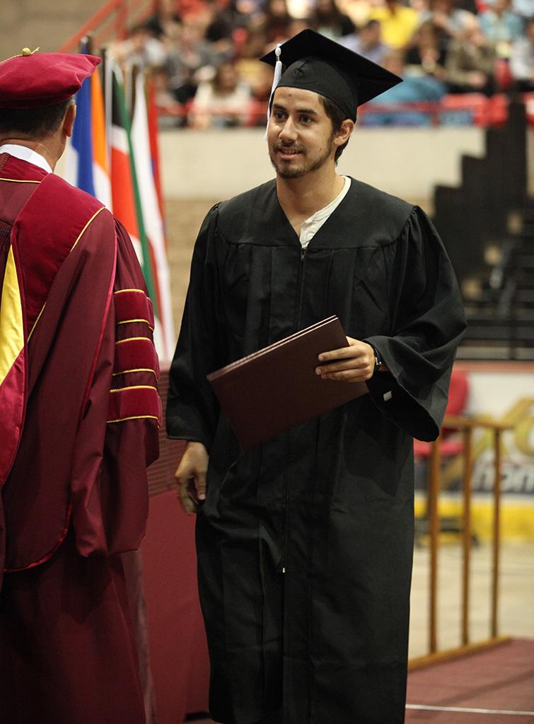 Mark Campbell, mass communication senior, walks across the stage after receiving his diploma at Midwestern State University graduation, May 16, 2015 at the Kay Yeager Coliseum. Photo by Francisco Martinez