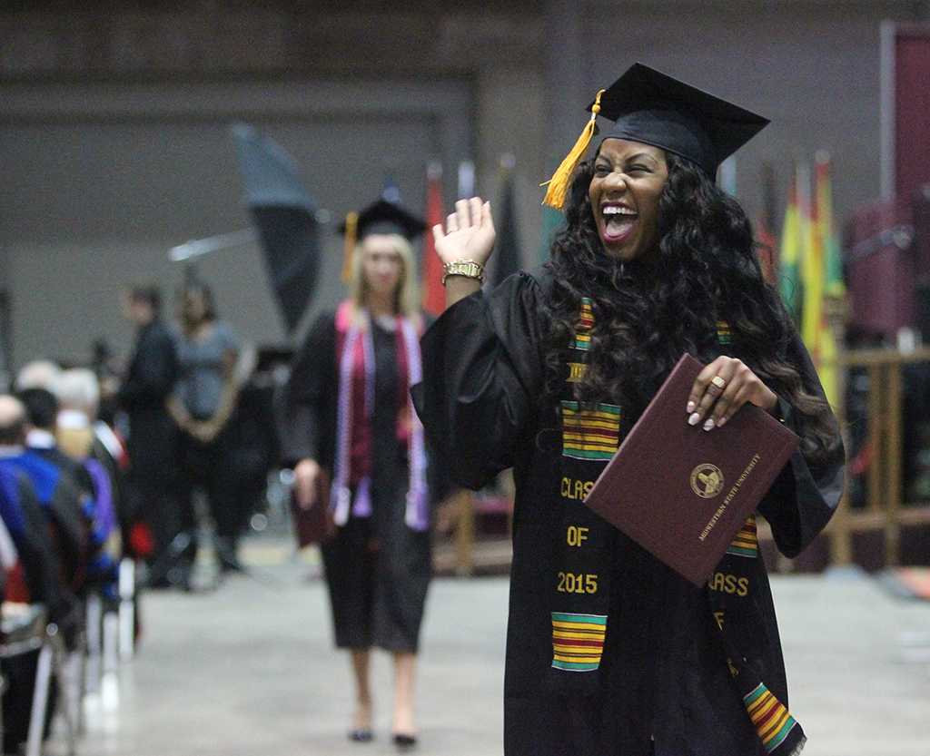 Farrellin Porter, nursing, sends a big wave tothe audience while walking back to her seat after receiving her diploma at Midwestern State University graduation, May 16, 2015 at the Kay Yeager Coliseum. Photo by Rachel Johnson