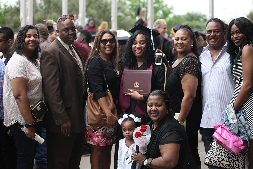 Chelsey Payne, interdisciplinary studies, family gathers to take a photo after the ceremony at Midwestern State University graduation, May 16, 2015 at the Kay Yeager Coliseum. Photo by Francisco Martinez