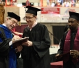 Retiring university President Jesse Rogers signs a copy of Sunwatcher magazine for Wichitan Editor Ethan Metcalf at Midwestern State University graduation, May 16, 2015 at the Kay Yeager Coliseum. Photo by Francisco Martinez