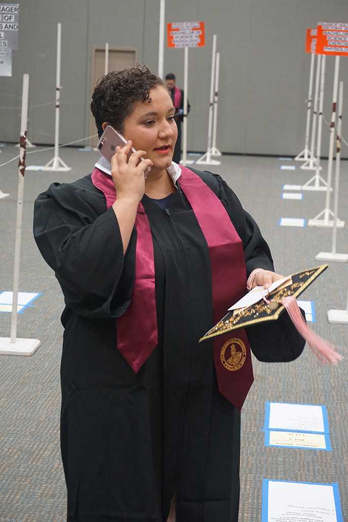 AnnMarie Bush, music, stops to take a phone call before lining up at the Midwestern State University graduation Dec. 17, 2016. Photo by Brendan Wynne