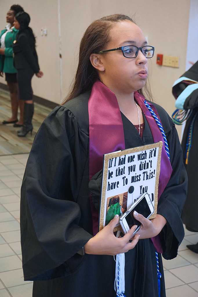 Courtney Gilder, mass communication graduate, waits for her friends to line up at the Midwestern State University graduation Dec. 17, 2016. Photo by Brendan Wynne