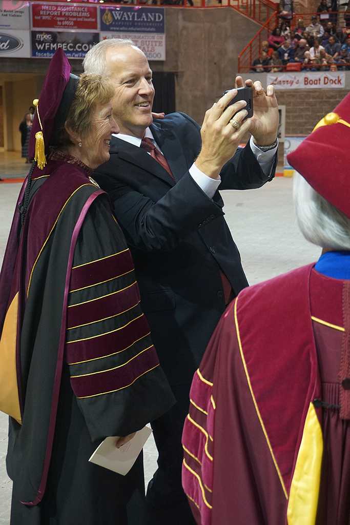 University president Suzanne Shipley stops to take a selfie with guest speaker James Frank at the Midwestern State University graduation Dec. 17, 2016. Photo by Brendan Wynne