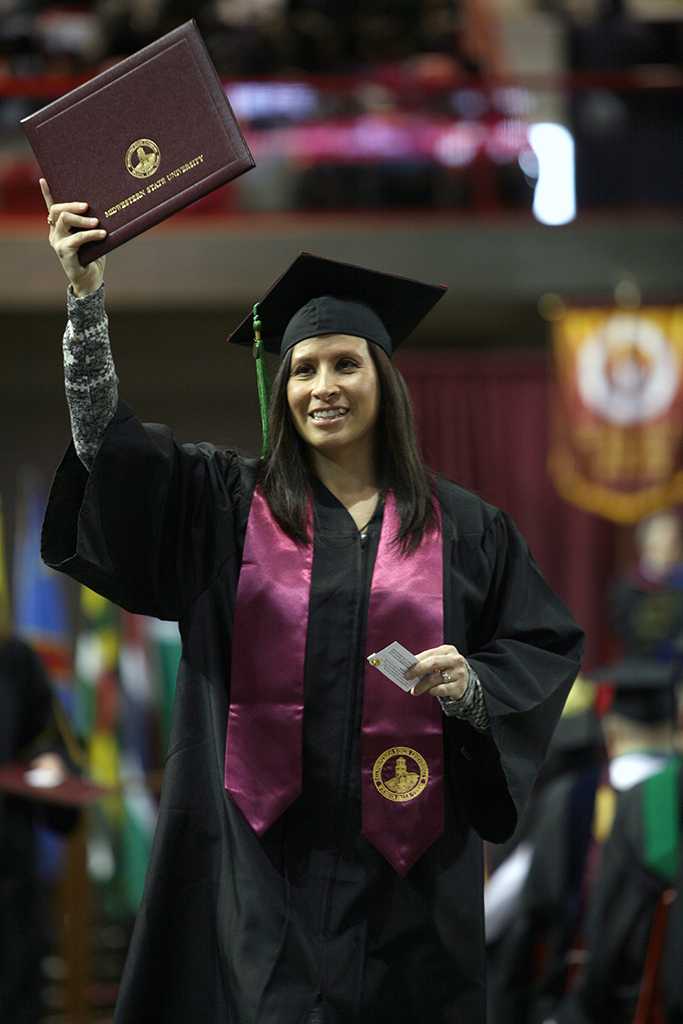 A gradute holds up her degree at Midwestern State University fall graduation Dec. 17, 2016. Photo by Brendan Wynne