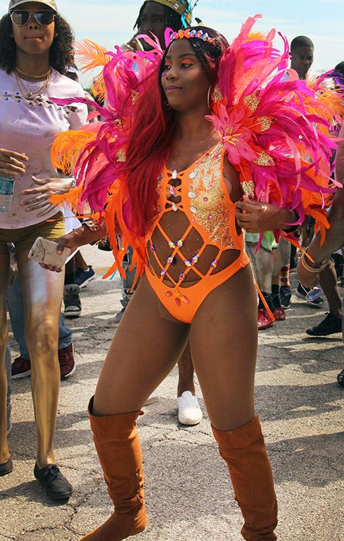 Kamilah Tobin, mass communication sophomore, dances in her bright feathered outfit during the Caribfest Parade that looped from Dillard to Jesse Rogers Promenade Sept. 30. Photo by Rachel Johnson