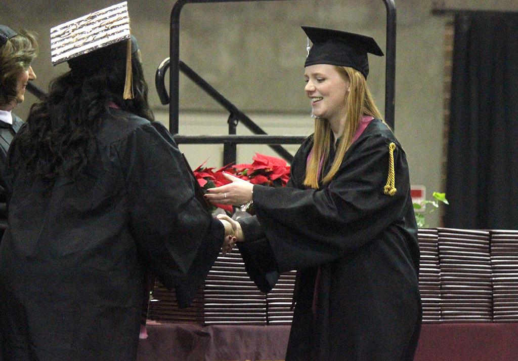 Emma Kate Winkles, education, is handed her degree as she cross the stage in Kay Yeager Coliseum, Sat. Dec. 16, 2017. Photo by Rachel Johnson