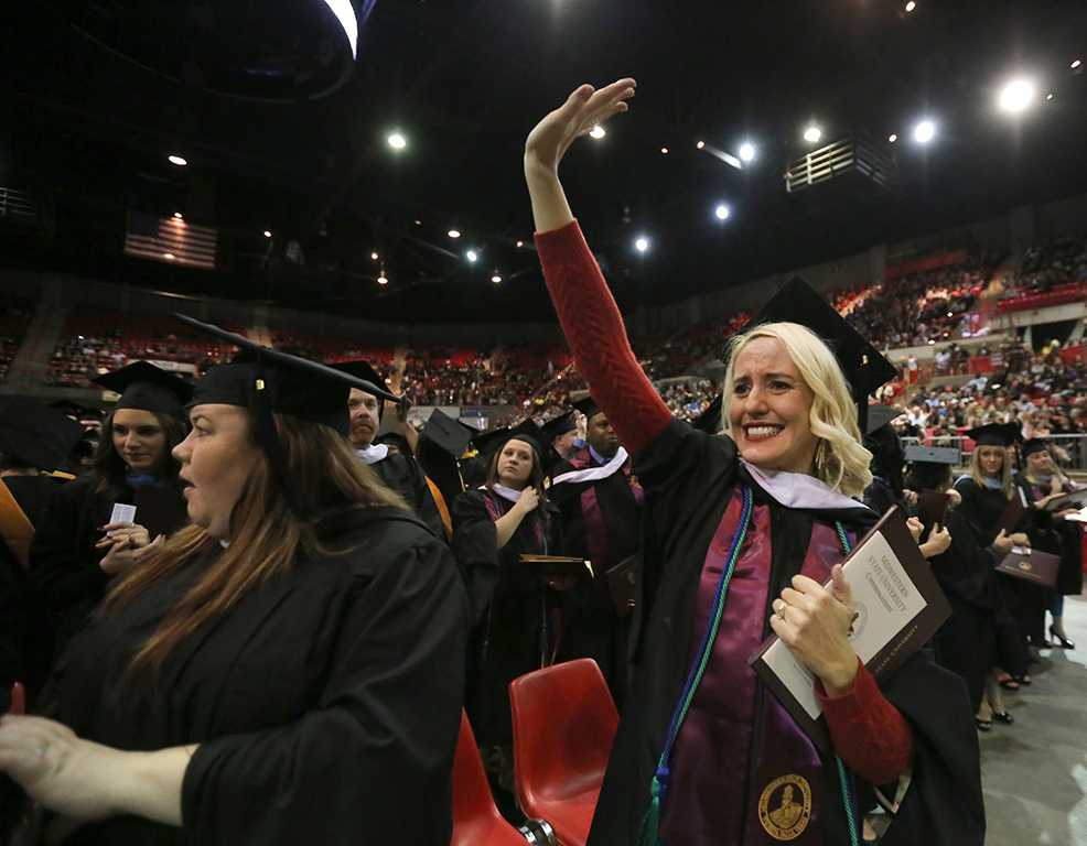 Linda Ross waves to her family and friends at graduation, Dec. 16, 2017. Photo by Bradley Wilson