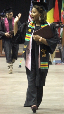 Jasmine Moody, criminal justice, waives at people inthe audience as she walk back to her seat after walking the stage and receiving her degree in Kay Yeager Coliseum, Sat. Dec. 16, 2017. " I didn't want to fall, that was my biggest concern, and I wanted to make sure I didn't blink in the middle of a photo and then you know the stairs. I want to give a shout-out to my mom," Moody said. Photo by Rachel Johnson
