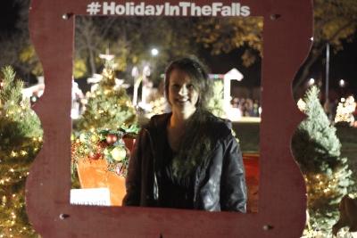 Michelle Chavez, music secretary, poses at the Holiday in the Falls picture frame at the MSU Burns Fantasy of Lights on the front lawn of the Hardin Building on Monday, Nov. 20, 2017. Photo by Justin Marquart