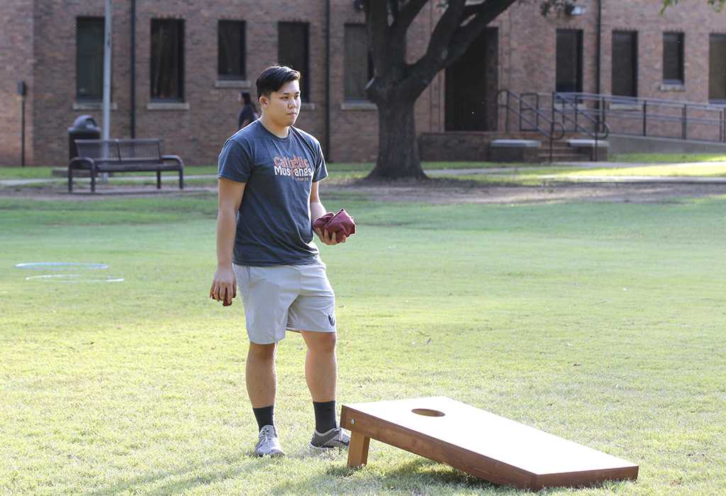 Johnny Dang, pre med sophomore, analyzes his cornhole shot at the homecoming field day competitions on Oct 18, 2017. Photo by Sara Keeling