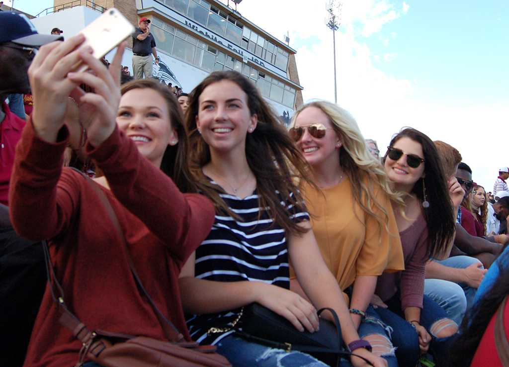 Allie Camp, undecided freshman, Maddie Bradberry, english freshman, Marley Eller, biology freshman, Caycee Griffin, biology freshman, take a seflie at the homecoming game on Saturday, Oct. 21, 2017. Photo by Shea James