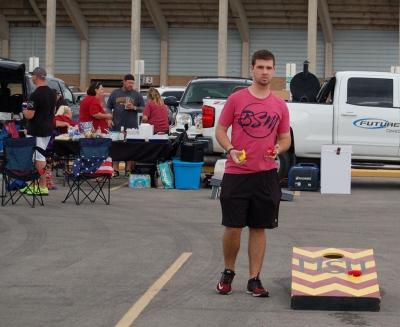 Justin Tompson, athletic trainer senior, plays corn hole in the BSM area at the homecoming tailgate on Saturday, Oct. 21, 2017. Photo by Shea James