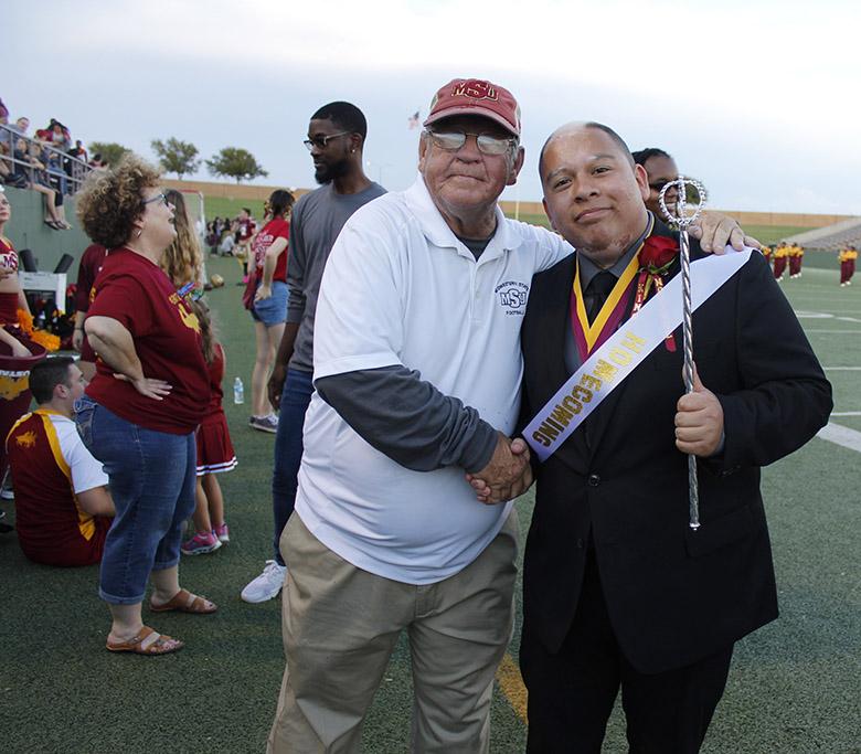 Juan Mercado, sociology senior , stands proudly for photos with Leroy McIlhaney after winning the title of King at the Homecoming game, Saturday Oct. 20, 2017. Photo by Sara Keeling