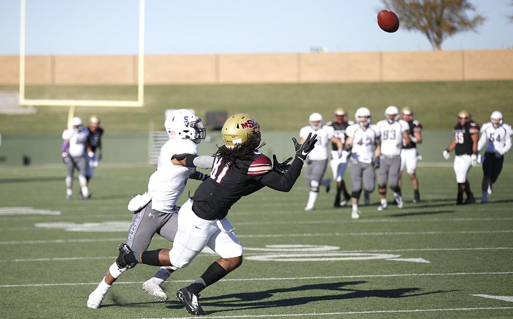 Wide receiver and mass communications freshman Daniel Petty attempts to catch a pass by quarterback and accounting junior Layton Rabb in the first round of the NCAA Division II playoffs against University of Sioux Falls. Nov 18. Photo by Bridget Reilly